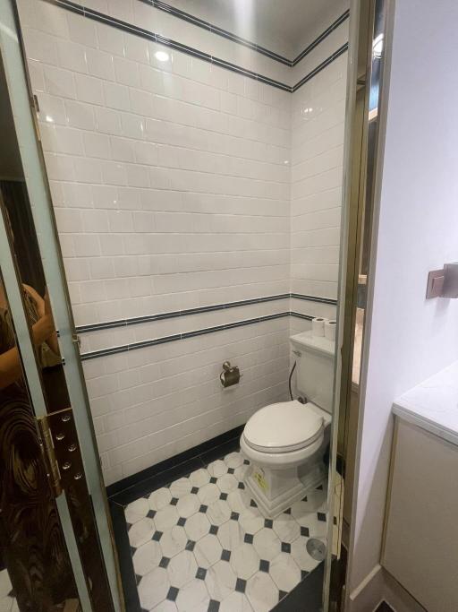 Compact bathroom with white tiles and glass shower door