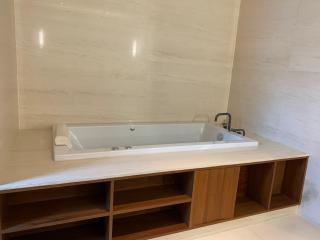 Modern bathroom with a large built-in bathtub and storage compartments