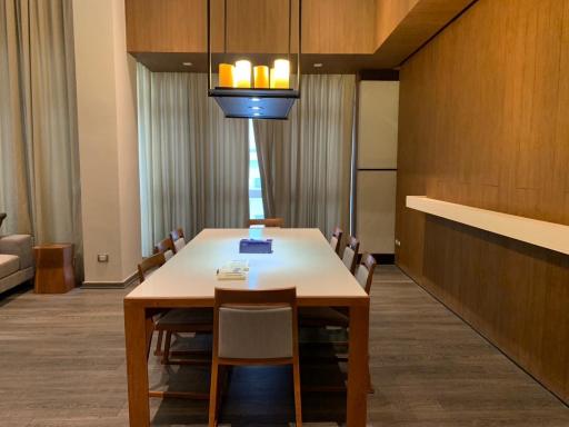 Spacious dining room with a modern wooden table, designer lighting, and elegant decor