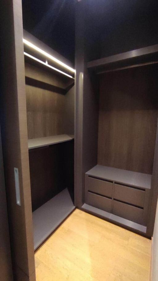 Modern walk-in closet with built-in shelves and lighting