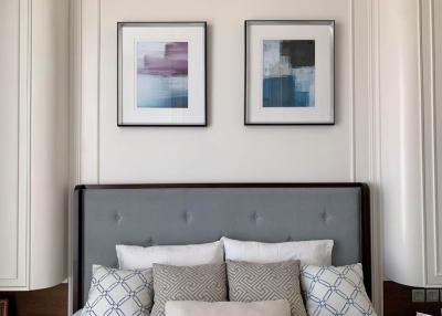 Elegant bedroom with framed artwork above a tufted headboard