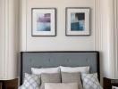 Elegant bedroom with framed artwork above a tufted headboard