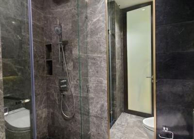 Modern bathroom with walk-in shower and dark stone tiles