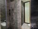 Modern bathroom with walk-in shower and dark stone tiles