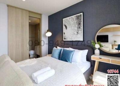 Modern bedroom with a large bed, framed artwork, and stylish furnishings