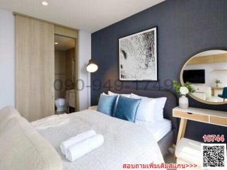 Modern bedroom with a large bed, framed artwork, and stylish furnishings