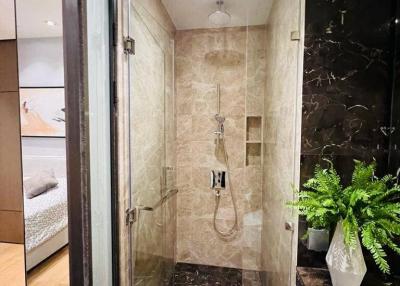 Modern bathroom with glass shower enclosure and marble tiles