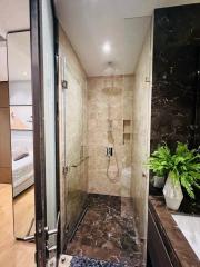 Modern bathroom with glass shower enclosure and marble tiles