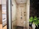 Modern bathroom with glass shower enclosure and marble tiles