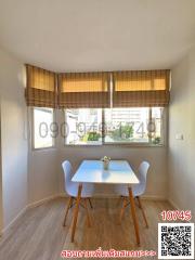 Bright dining area with large window and modern furniture