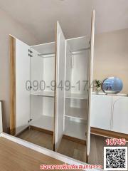 Bedroom with open wardrobe and white storage furniture