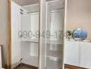 Bedroom with open wardrobe and white storage furniture