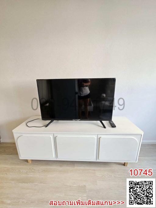 Modern living room with large flat screen TV and white TV stand