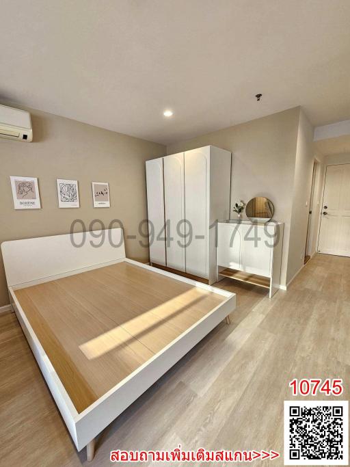 Spacious modern bedroom with laminate flooring and ample natural light