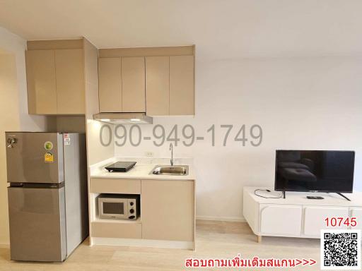 Modern small-scale combined kitchen and living area with appliances and entertainment setup
