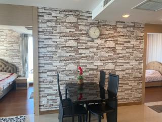 Modern dining area with stone accent wall and adjacent bedroom view