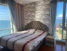 Modern bedroom with an ocean view and brick accent wall