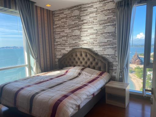 Modern bedroom with an ocean view and brick accent wall