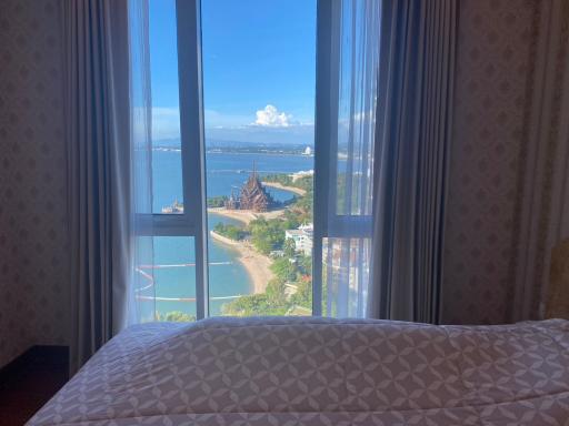 Bright bedroom with an ocean view and clear skies