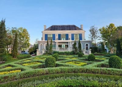 Luxurious two-story house with a manicured garden and solar panels