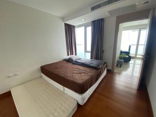 Spacious bedroom with large bed, hardwood floors, and sea view