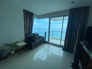 Cozy living room with ocean view and balcony access