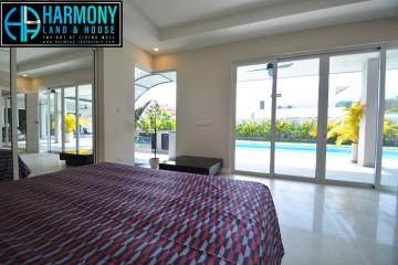 Spacious bedroom with pool view and large glass doors