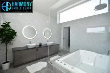 Modern bathroom with marble tiles, dual sinks, and a large bathtub