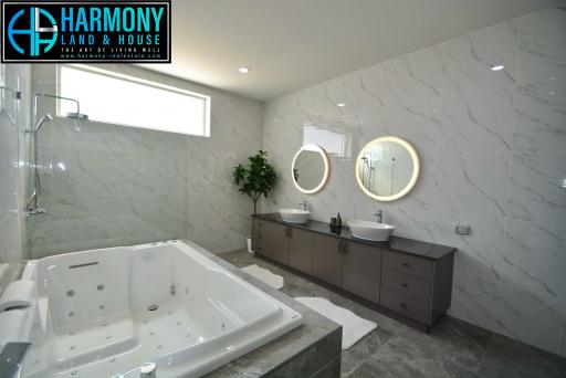 Modern bathroom with marble tiles featuring a whirlpool tub, double vanity, and glass shower enclosure