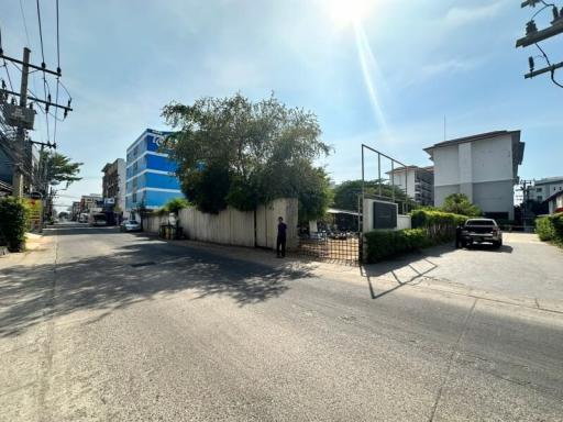 Street view of a property with surrounding buildings and greenery