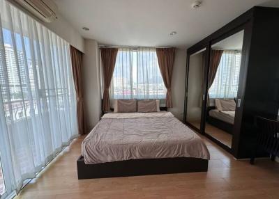 Spacious bedroom with queen-sized bed and city view