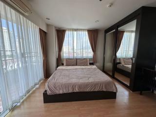 Spacious bedroom with queen-sized bed and city view