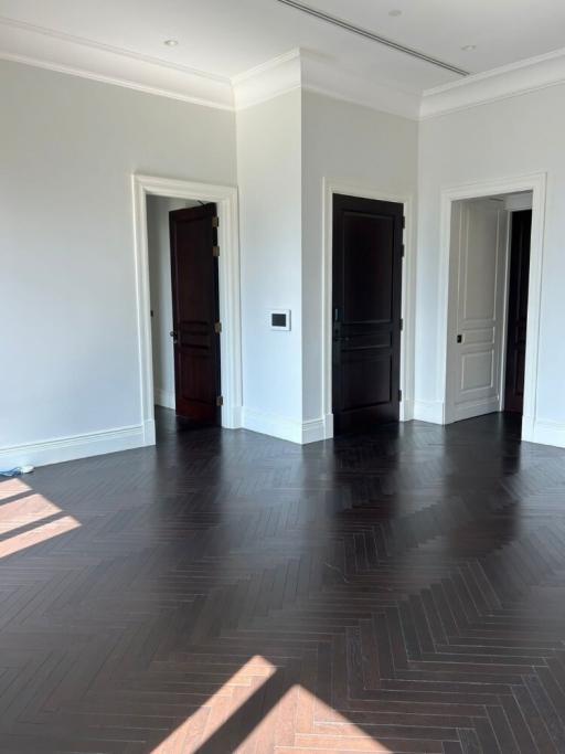 Spacious interior of a building showing dark wooden floors and white walls