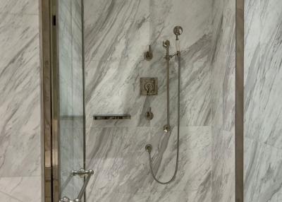 Elegant bathroom with marble walls and glass shower cabin