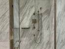 Elegant bathroom with marble walls and glass shower cabin