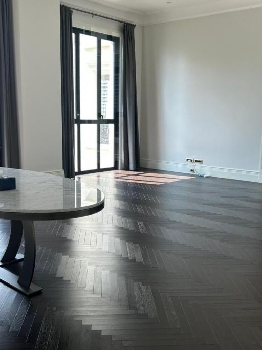 Spacious living room with dark hardwood floors and natural light