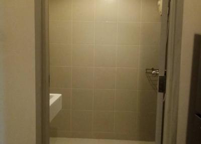 Compact bathroom with beige tiles and lighting