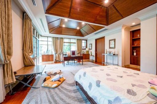 Spacious bedroom with elegant wooden ceiling and ample natural light