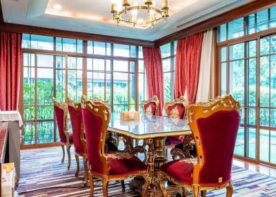 Elegant dining room with ornate wooden table and chairs with garden view