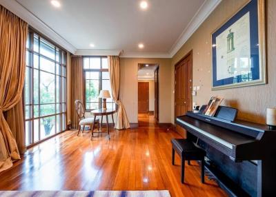 Spacious living room with hardwood floors and piano