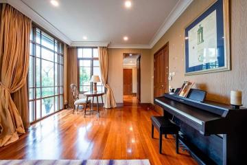 Spacious living room with hardwood floors and piano