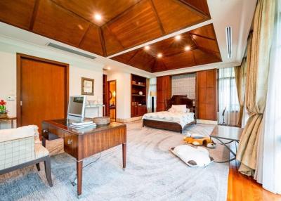 Spacious and well-lit master bedroom with elegant wooden furnishings and attached bathroom
