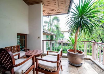 Spacious balcony with seating arrangement and large potted plant