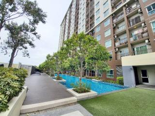 Modern apartment complex with outdoor swimming pool and landscaped garden