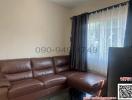 Cozy living room with brown leather sofa and natural light