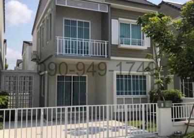 Two-storey residential house with a gray facade and white fence