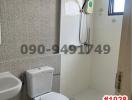 Compact tiled bathroom with modern fixtures and wall-mounted shower