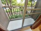 Cozy balcony with garden view and clear sliding glass doors