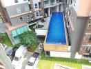 High-angle view of a residential building's outdoor communal area with swimming pool