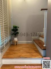 Cozy staircase landing with wood flooring and a small decorative plant
